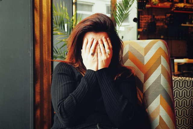 A woman covering her eyes with her hands.